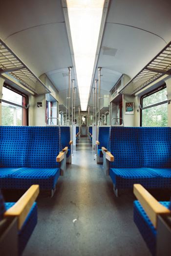 the inside of a train with blue benches